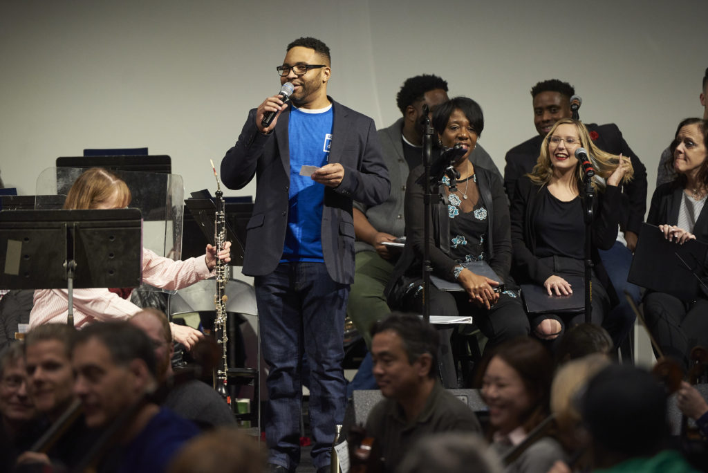 Joseph Garnier welcomes people to community sing.